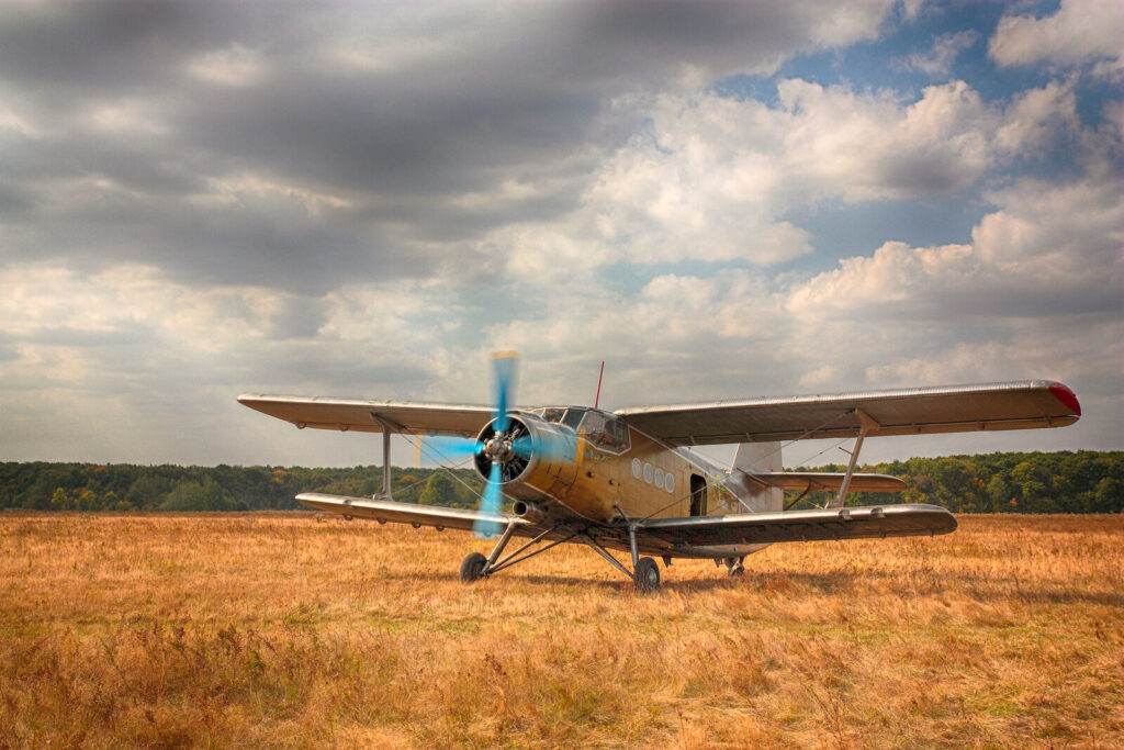 An aircraft on the ground Old biplane parked on a dry grass airfield