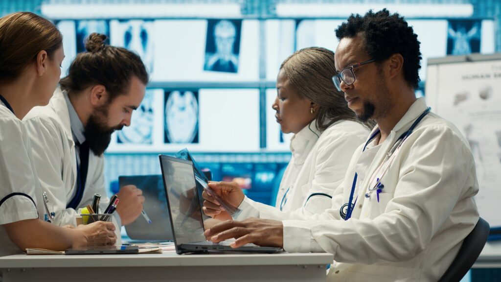 Evidence from a trial Team of clinicians working at laptops with medical images on the wall behind them