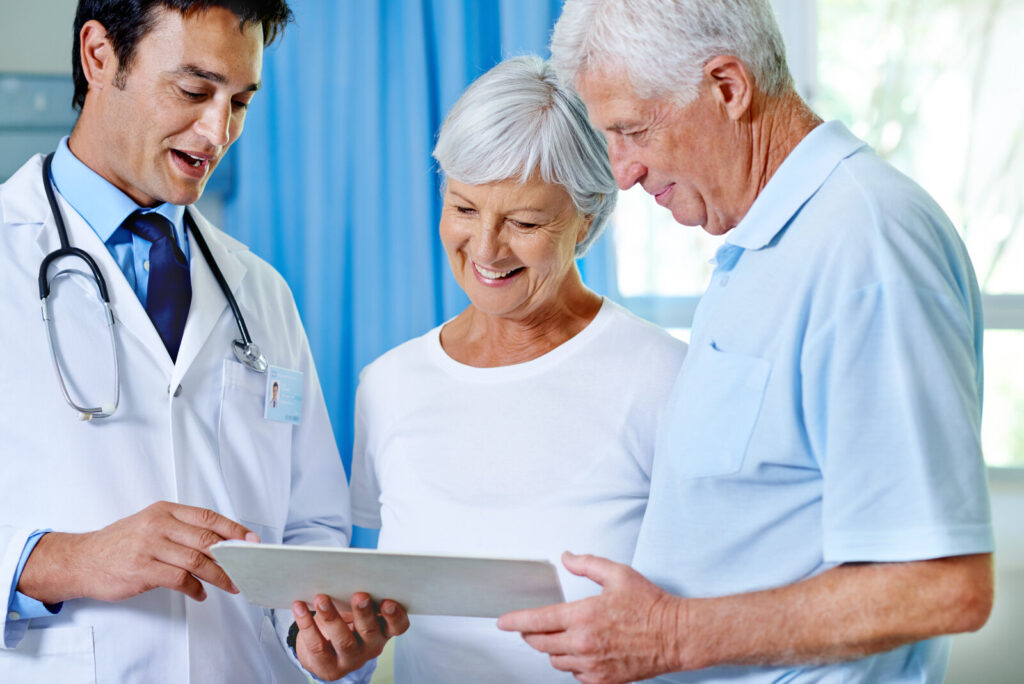 What matters to patients Doctor showing results on a tablet to an older couple