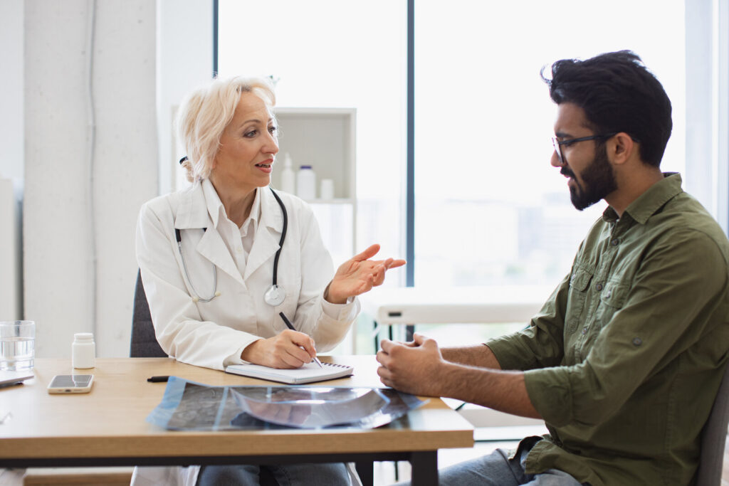Trial participants Doctor talking with a patient across a desk in a clinic