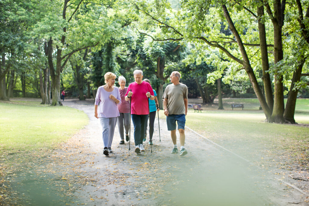 Group of older adults walking together on a park path