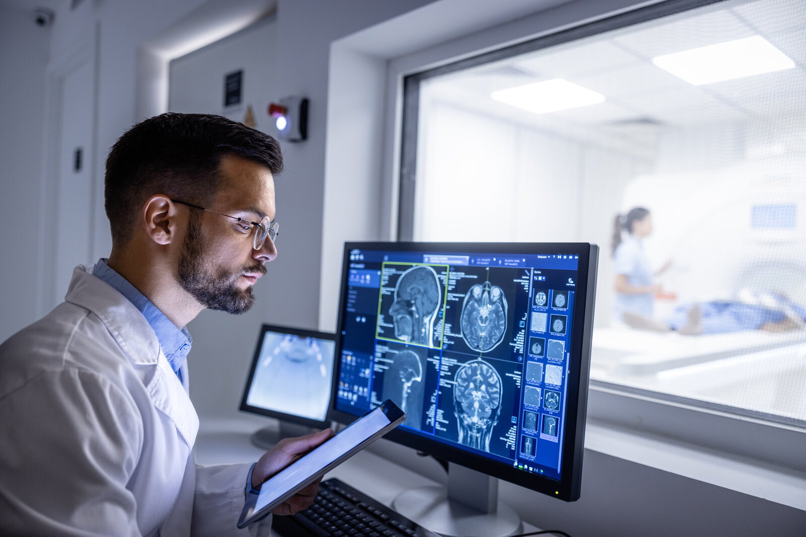 Radiologist reviewing a brain scan on a computer monitor in an imaging department