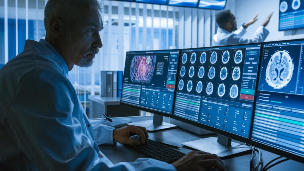 Researcher studying brain scan images across several computer monitors