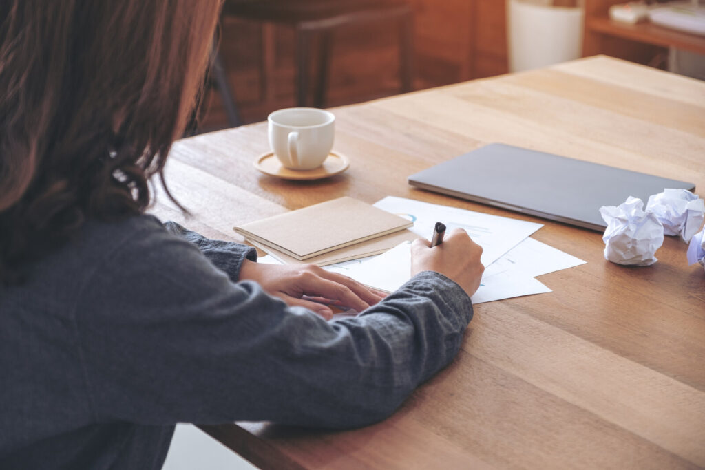 Reviewing a paper Person at a wooden table reading and marking up printed pages