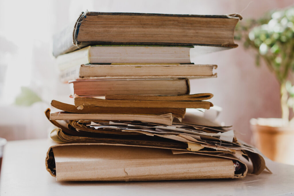 Stack of old books and yellowed papers on a table