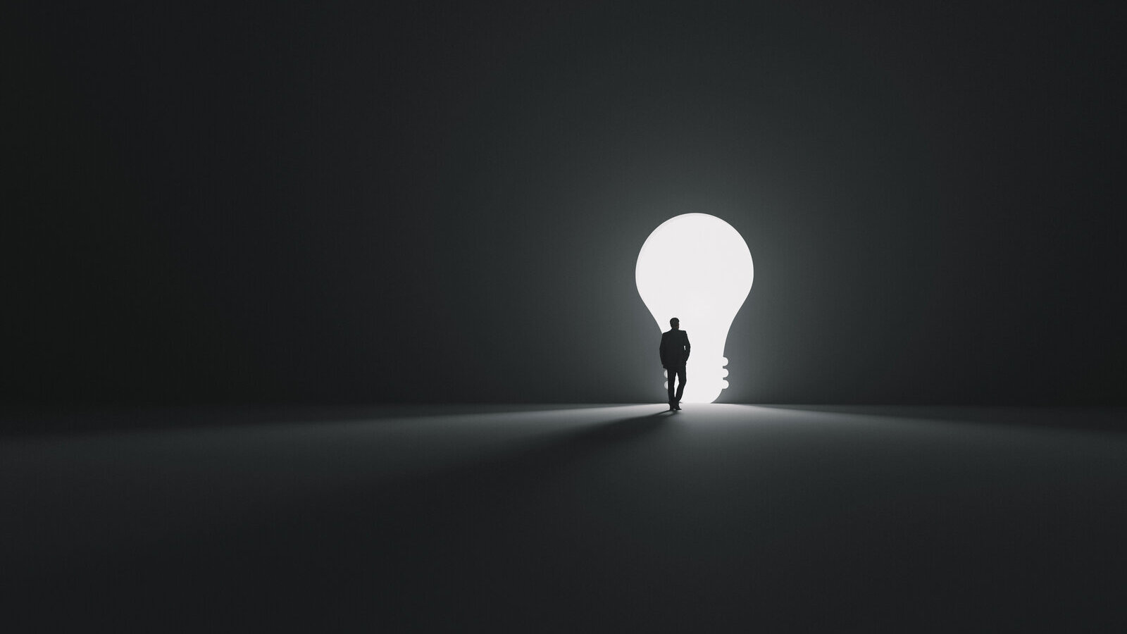 Small figure walking toward a bright opening shaped like a light bulb in a dark room