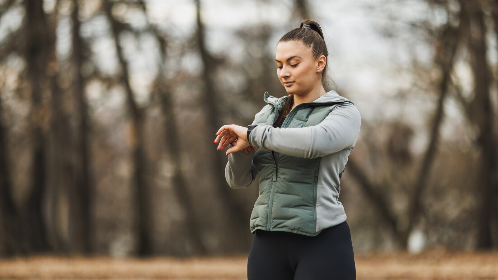 Woman on a park path checking her smartwatch