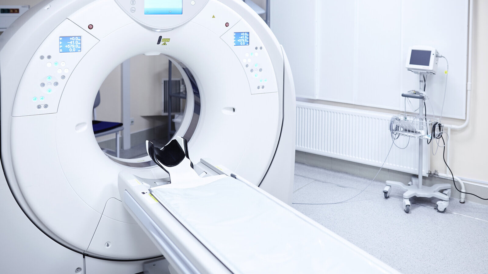 Empty CT scanner with its patient table in a hospital scan room